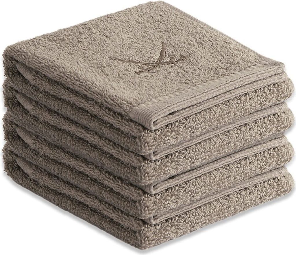 A stack of taupe guest towels with a subtle embroidered design on the top towel.