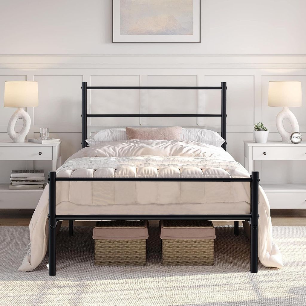 A black metal bed frame with a mattress and bedding is shown in a bedroom setting.