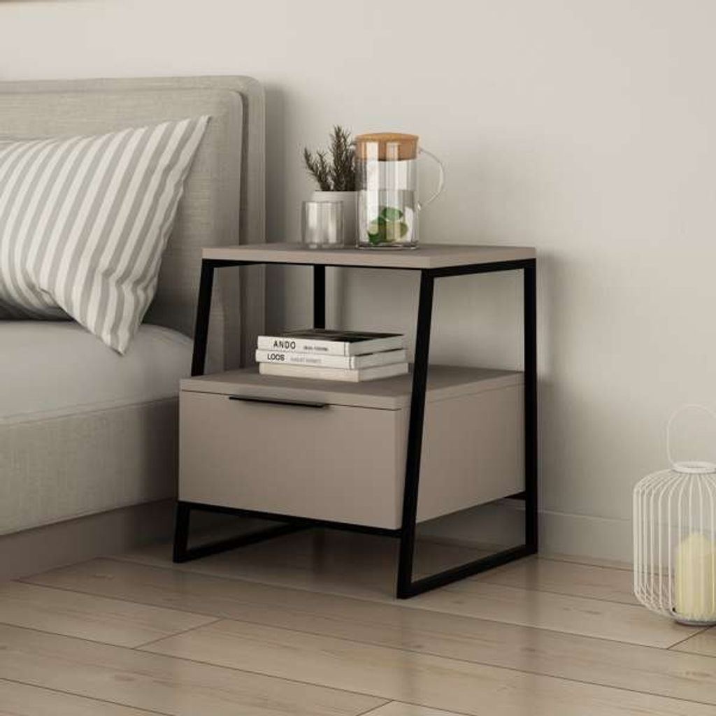A modern nightstand with a drawer next to a bed, decorated with a pitcher of water, a plant, and books.