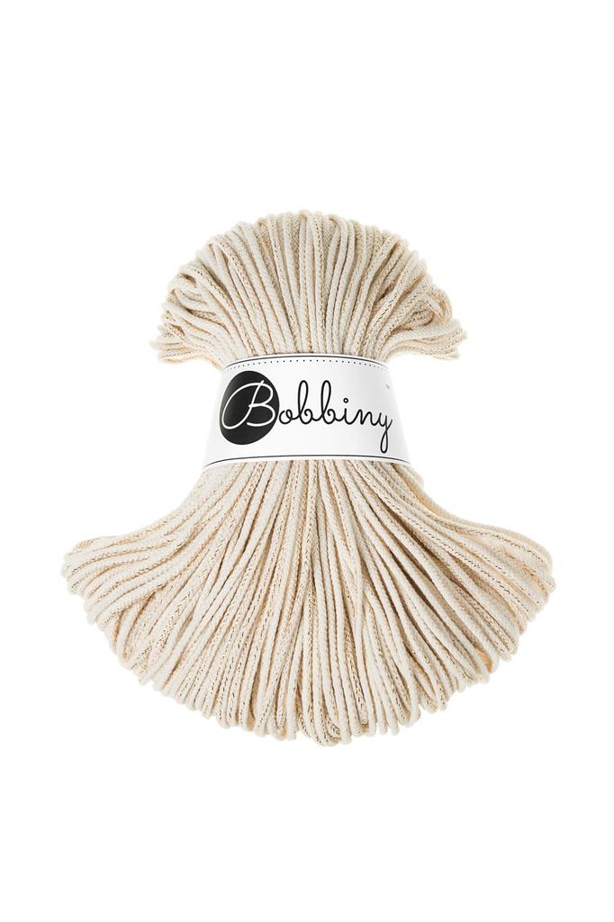 A spool of beige macrame cord with a label.