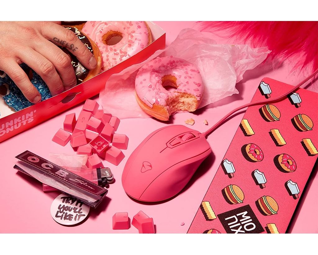 A pink gaming mouse, donuts, and other items are arranged on a pink surface.