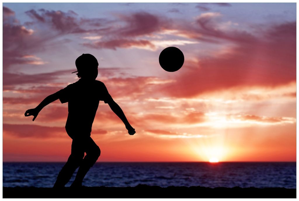 Wallario Wandbild aus Acryl, 90 x 60 cm, freischwebende Optik - Fußball - Kleiner Junge spielt im Abendrot