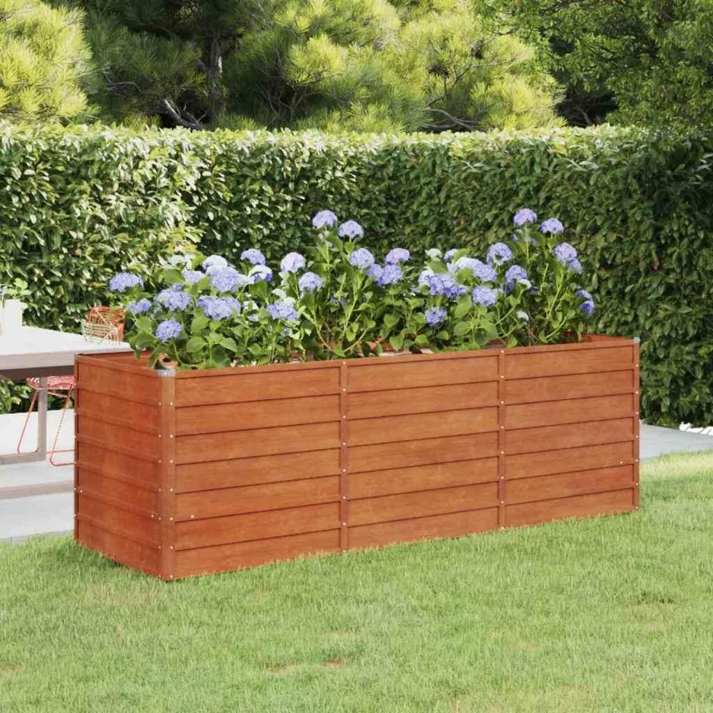 A wooden planter box filled with purple hydrangeas sits on a green lawn, with a hedge and trees in the background.