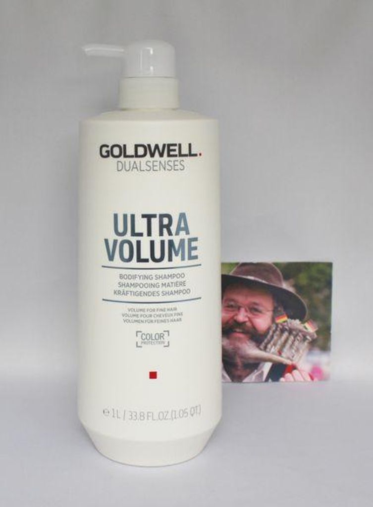 A bottle of Goldwell Dualsenses Ultra Volume Bodifying Shampoo is shown next to a small printed photograph of a man.