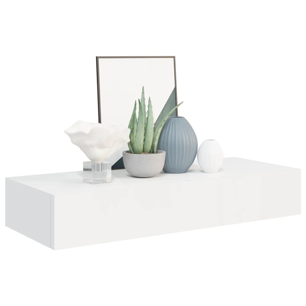 A white floating shelf with decorative items on it.