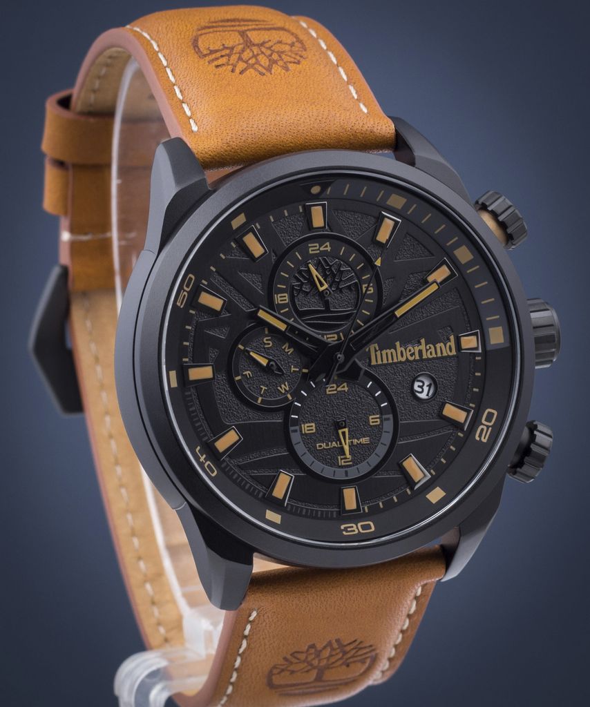 A Timberland men's watch with a black dial and a brown leather strap, shown against a dark blue background.