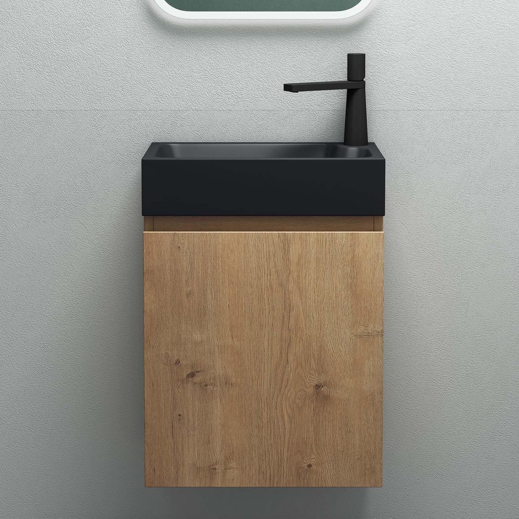 A modern bathroom vanity with a black sink and a wood-grain cabinet against a gray tiled wall.