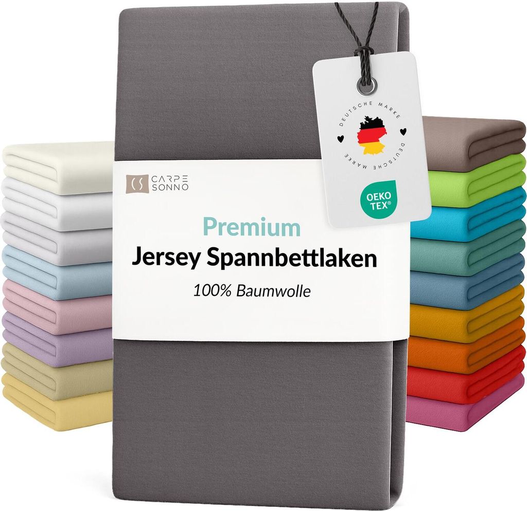A stack of folded bed sheets in various colors, with a gray sheet prominently displayed in the foreground and a tag attached to it.