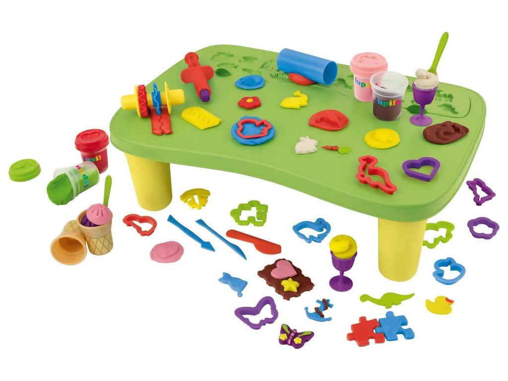A play table with various clay molding tools and accessories scattered around it.
