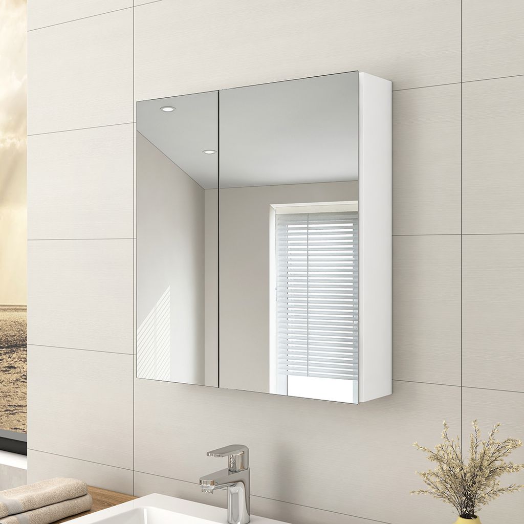 A white bathroom cabinet with mirrored doors is mounted on a tiled wall above a sink and faucet.