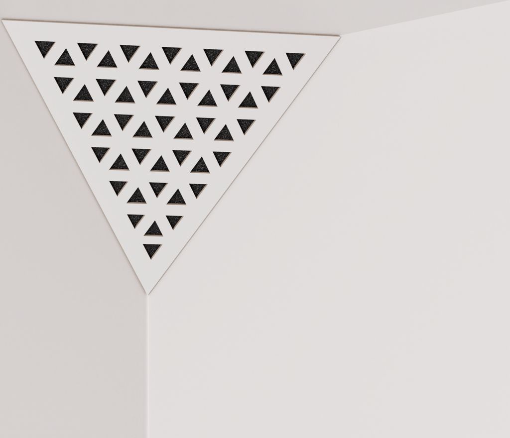 A white triangular acoustic foam panel with a perforated HDF plate is shown in a corner where two walls meet.