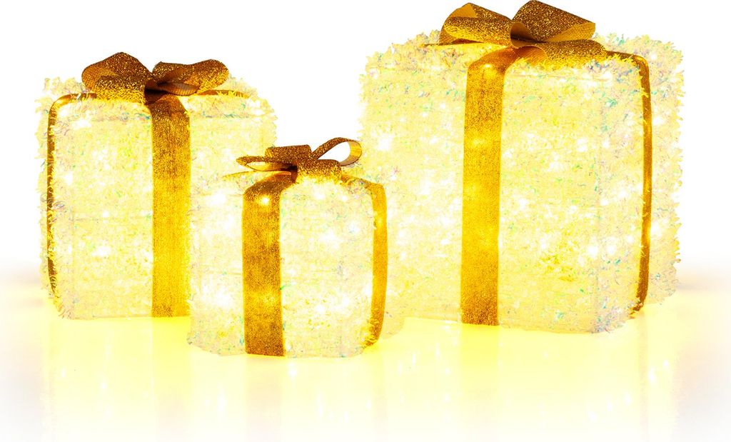 Three illuminated gift boxes with gold ribbons and bows, displayed on a white surface with a yellow glow underneath.