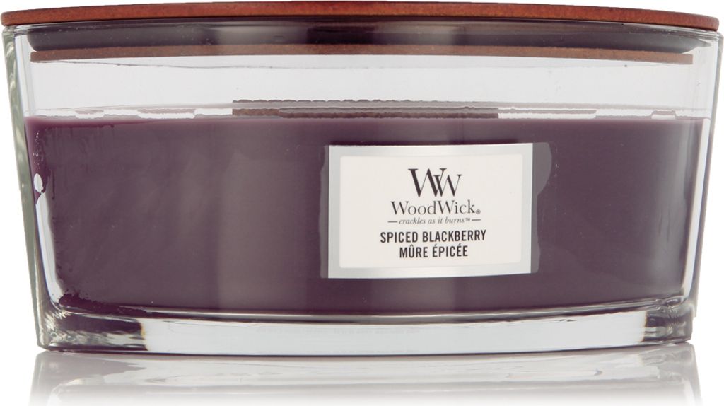 A WoodWick Spiced Blackberry scented candle in a clear glass jar with a wooden lid.