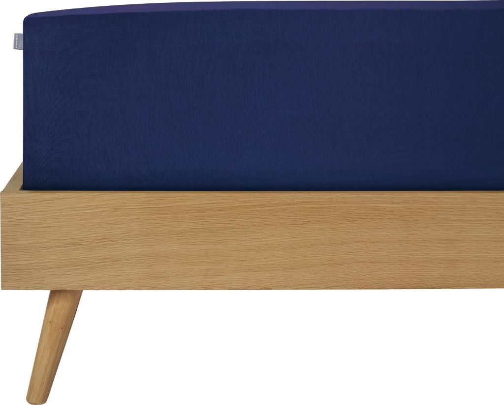 A close-up view of a dark blue fitted sheet on a wooden bed frame.