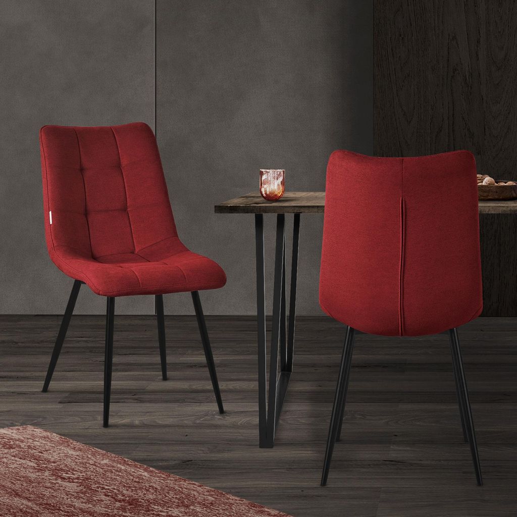 Two red chairs are placed around a wooden table in a dining room setting.