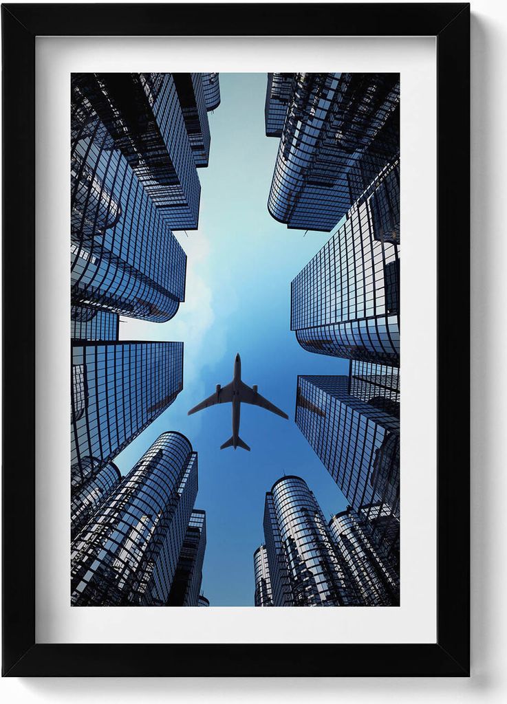 Flugzeug über Gebäuden– Wandbild mit Rahmen – Gerahmtes Bild – Wanddekoration – 20x30 cm – Schwarz