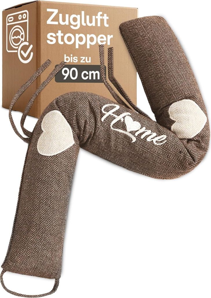 A brown fabric draft stopper with white heart and 'Home' embroidery, placed in front of its cardboard packaging.