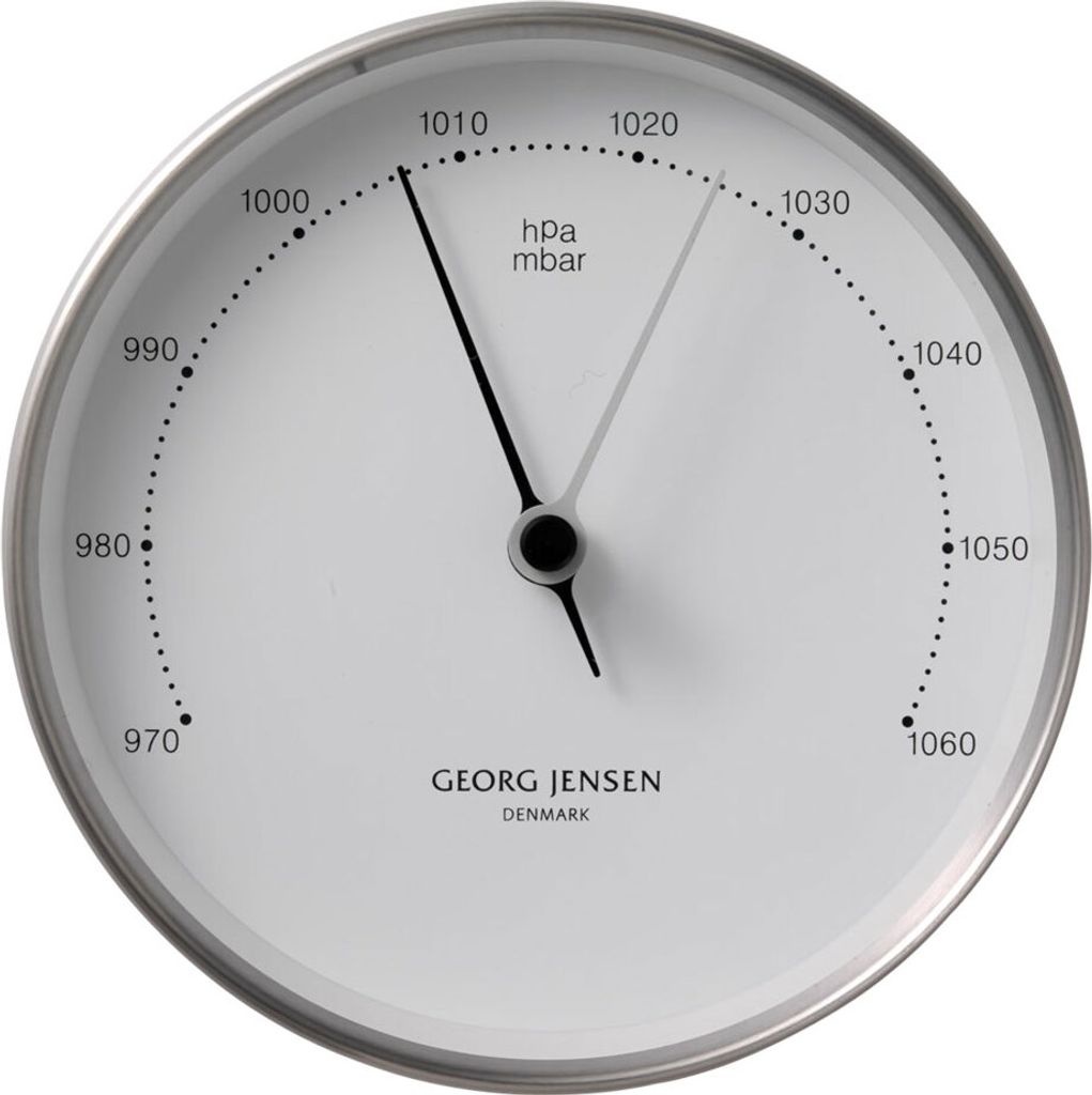 A white barometer with black markings and hands, set in a silver frame.