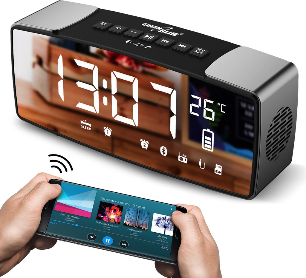 A digital alarm clock with a mirrored display is shown, with a smartphone in the foreground displaying music playback.