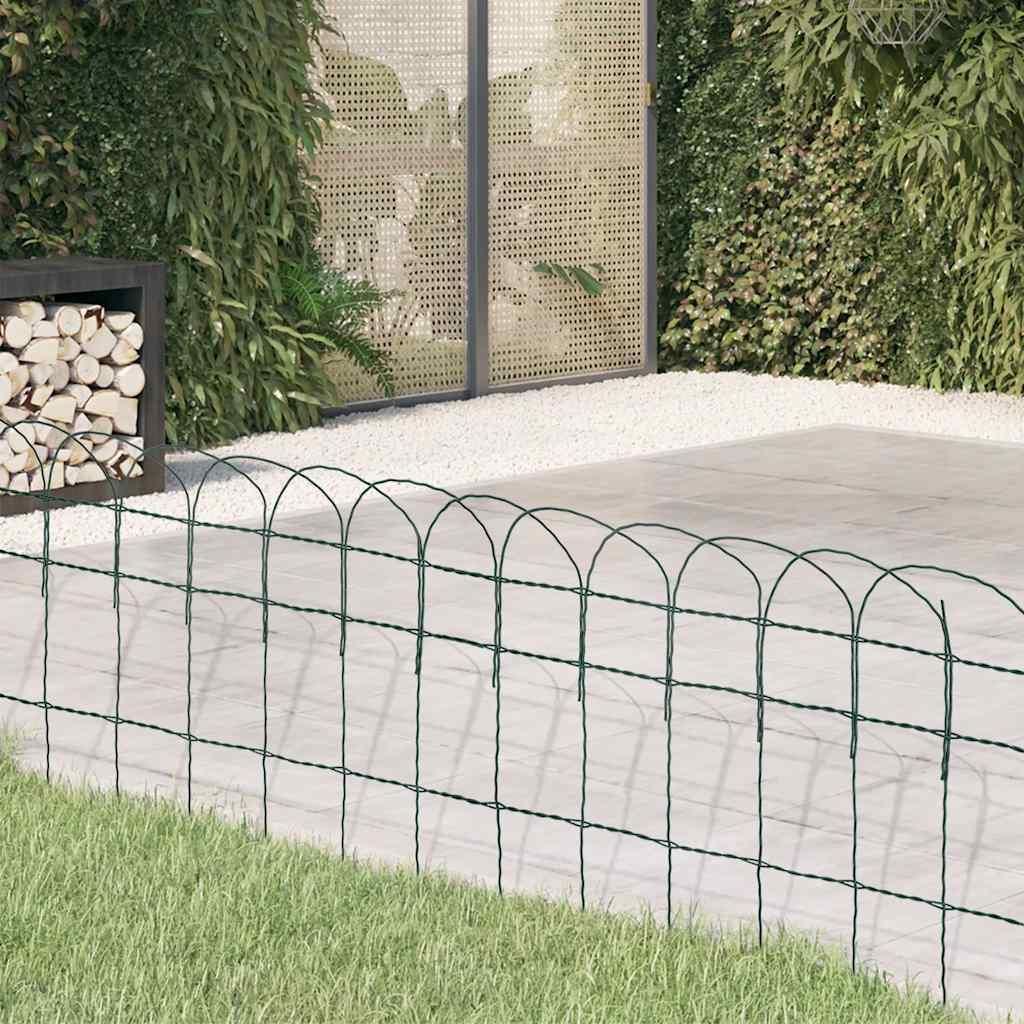 A green wire garden border fence in front of a patio and greenery.