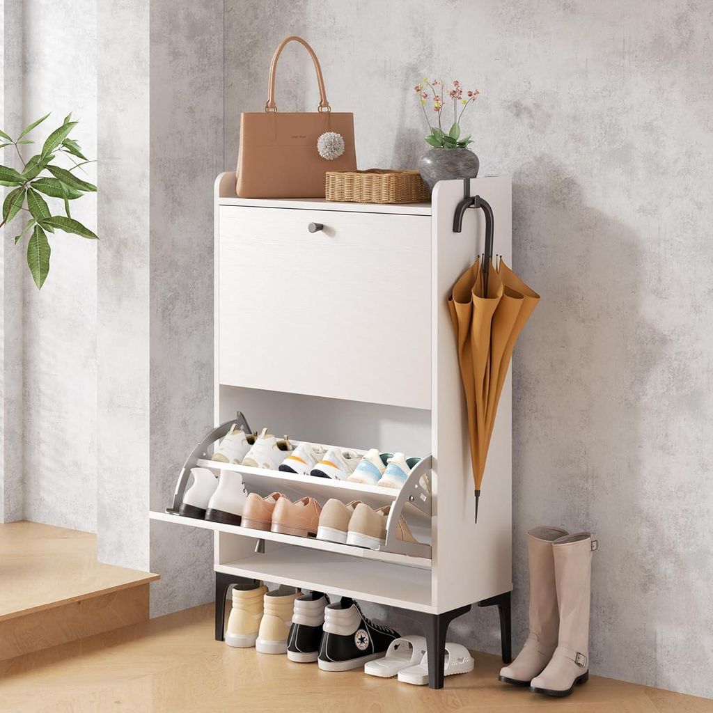 A white shoe cabinet with a brown handbag and umbrella on top, placed in a room with a textured wall.
