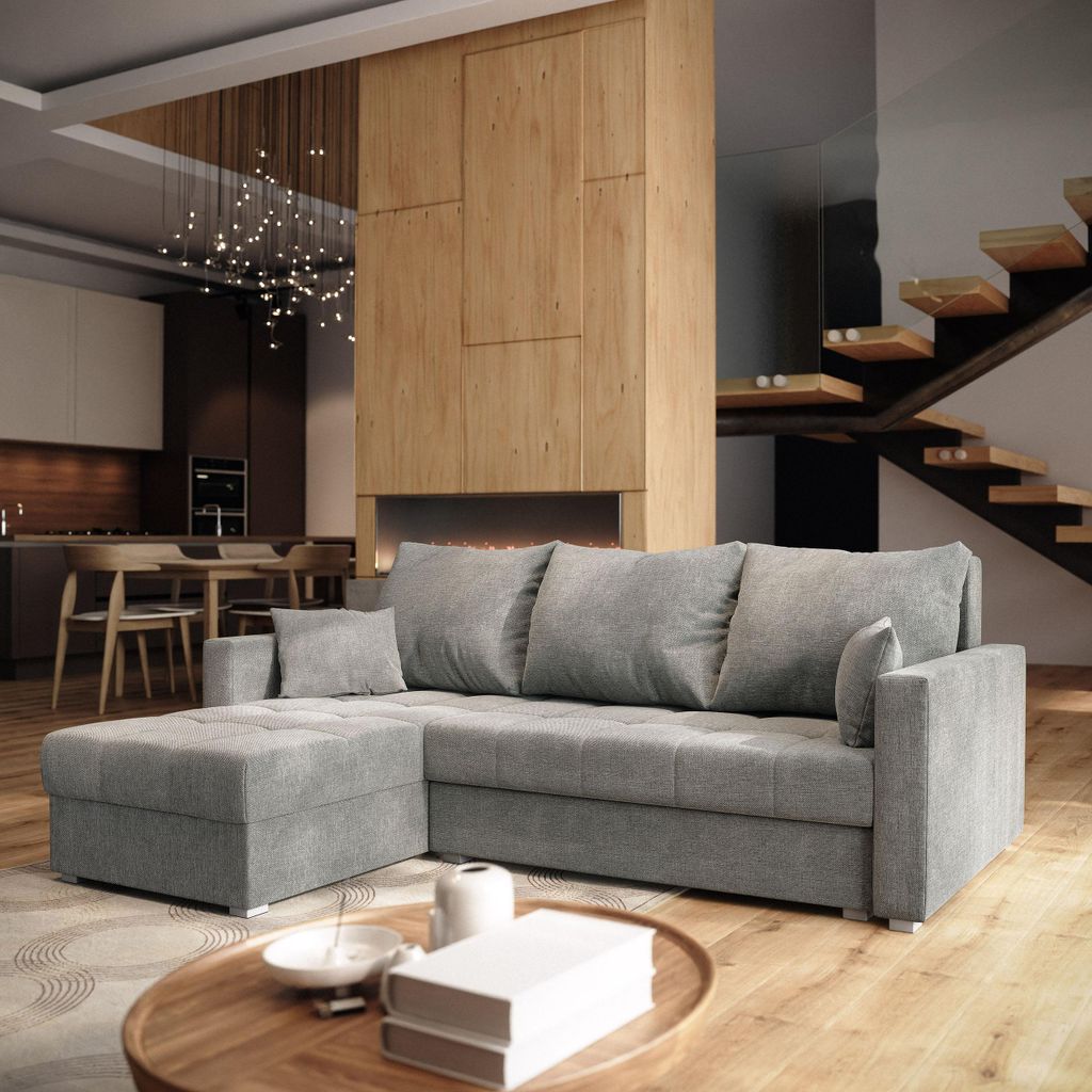A modern living room with a sectional sofa, coffee table, and staircase.