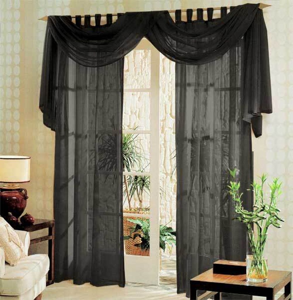 A set of black sheer curtains with a decorative valance draped over a curtain rod, covering a French door.
