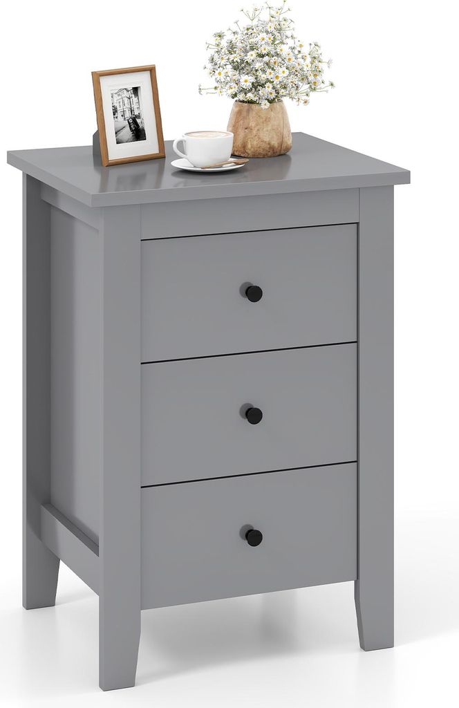 A gray three-drawer nightstand with a framed photo, a cup of coffee, and a vase of flowers on top.