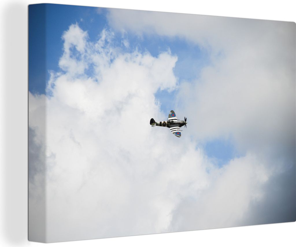 OneMillionCanvasses - Leinwandbilder - 150x100 cm, Spitfire-Flugzeug in einem bewölkten Himmel, Wandbilder Kunstdruck Wanddekoration