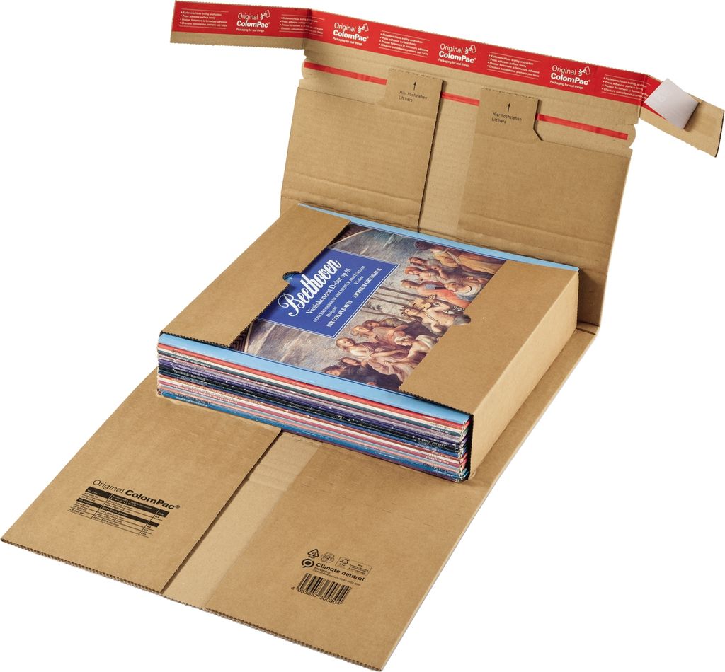 An open cardboard shipping box with a stack of books or similar items inside.