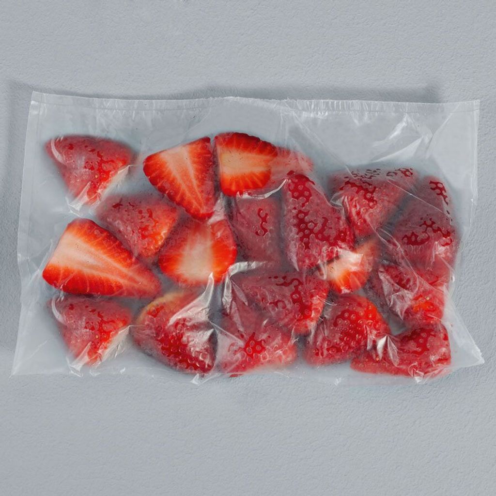 Sliced strawberries in a clear plastic bag.