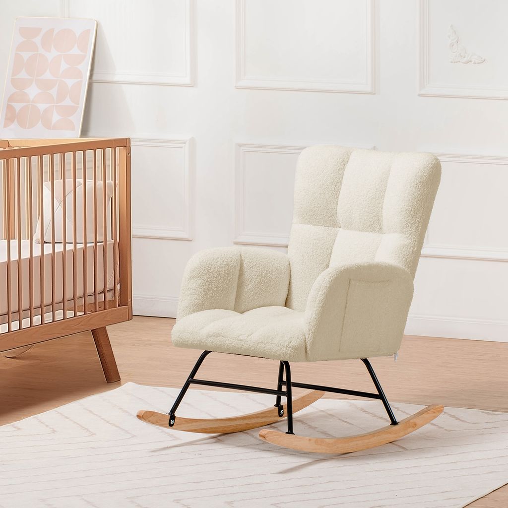 A beige teddy plush rocking chair is shown in a nursery setting next to a wooden crib.