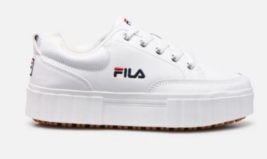 A white Fila sneaker with a platform sole is shown against a white background.