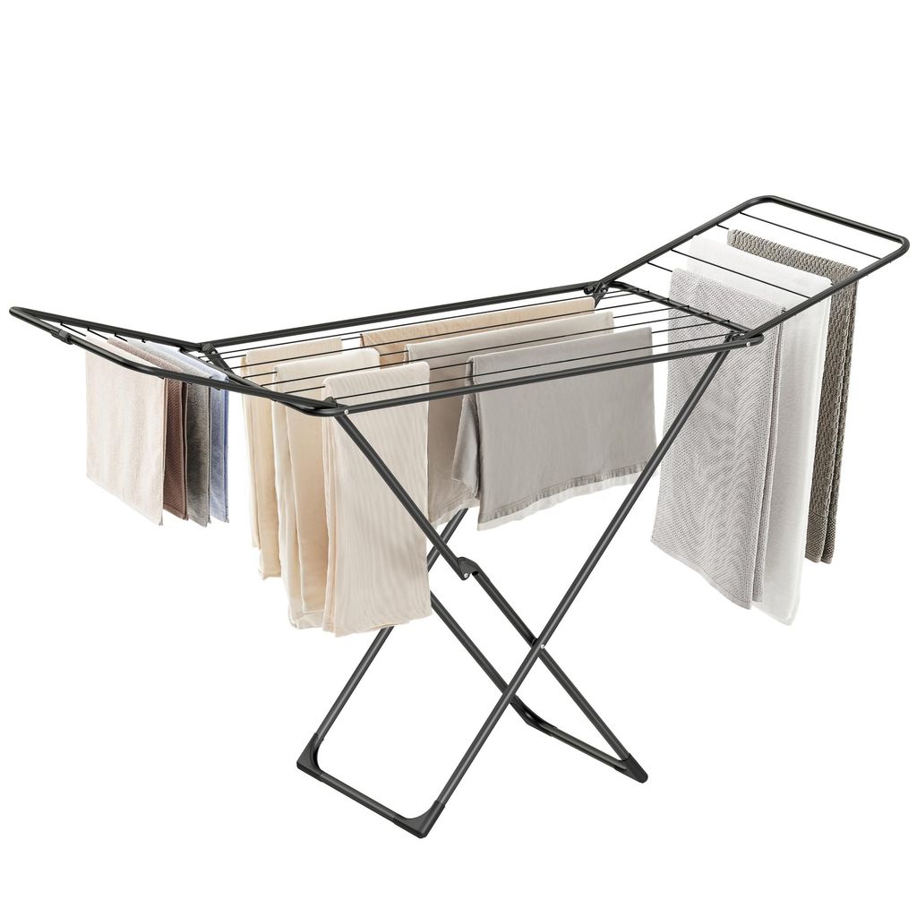 A black folding clothes drying rack with several towels and cloths draped over it, set against a white background.