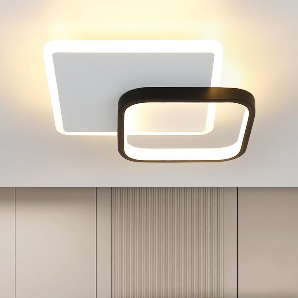 A modern ceiling light fixture with two overlapping square frames, one white and one black, mounted on a white ceiling.