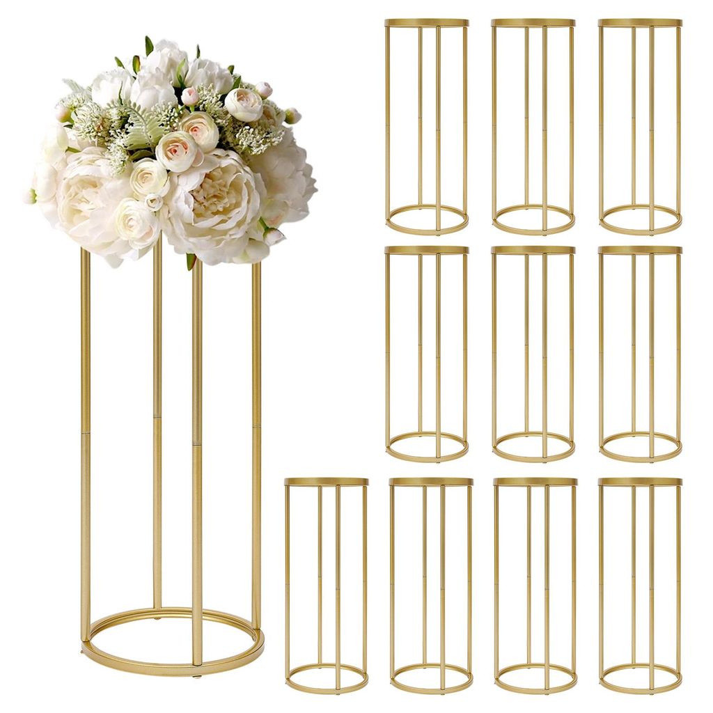 A bouquet of white flowers is displayed on a tall, gold cylindrical stand, with a set of identical gold stands arranged in the background.
