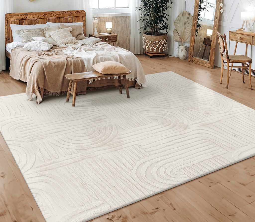 A bedroom scene with a bed, rug, and furniture.