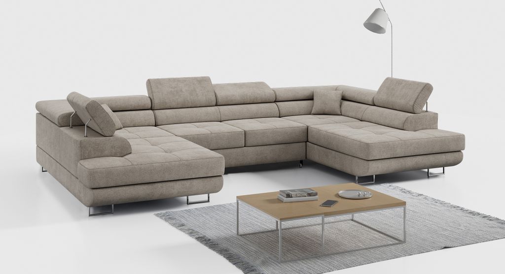 A beige sectional sofa is shown in a studio setting with a coffee table and a floor lamp.
