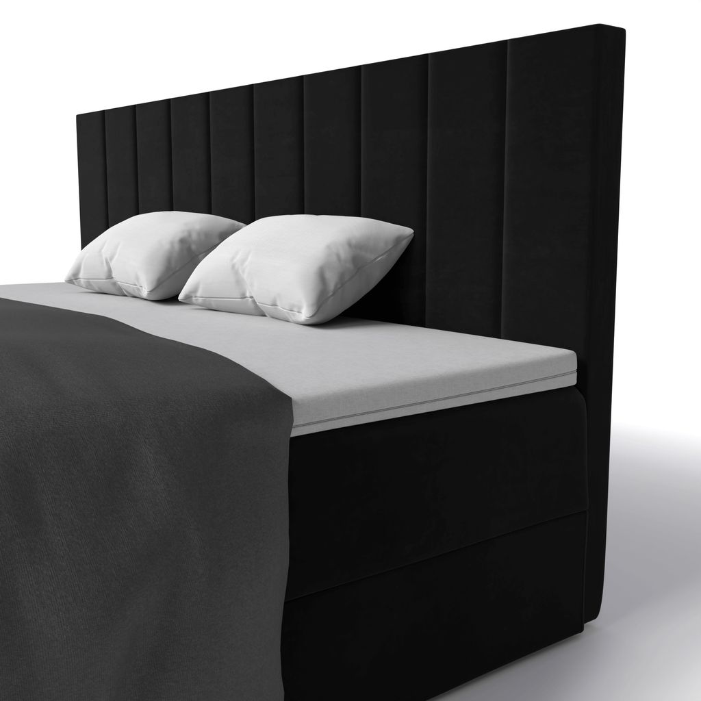 A black boxspring bed with white pillows and a dark gray blanket, shown from a side angle against a white background.