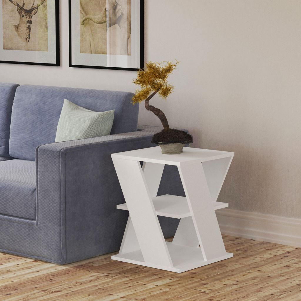 A modern white side table with a bonsai tree on top, placed next to a blue sofa in a living room.