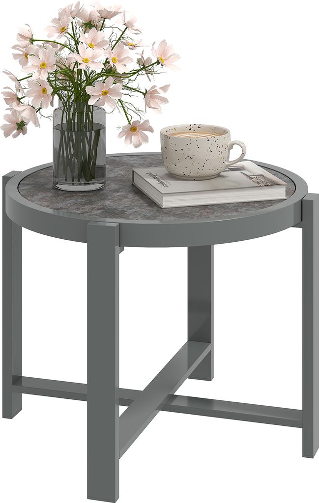 A round side table with a vase of flowers and a cup of coffee on it.