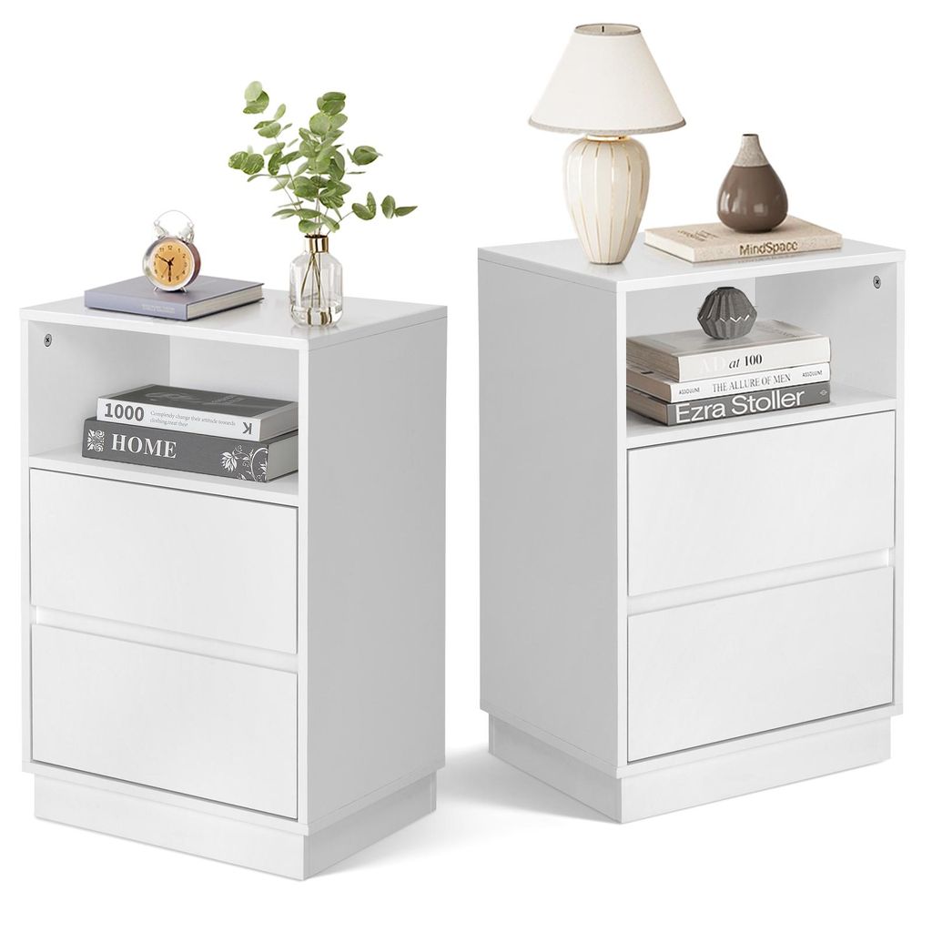 Two white bedside tables are shown side-by-side against a white background. The table on the left has a book, a clock, and a vase with greenery on top, and two drawers below. The table on the right has a lamp, a vase, and books on top, and two drawers belo
