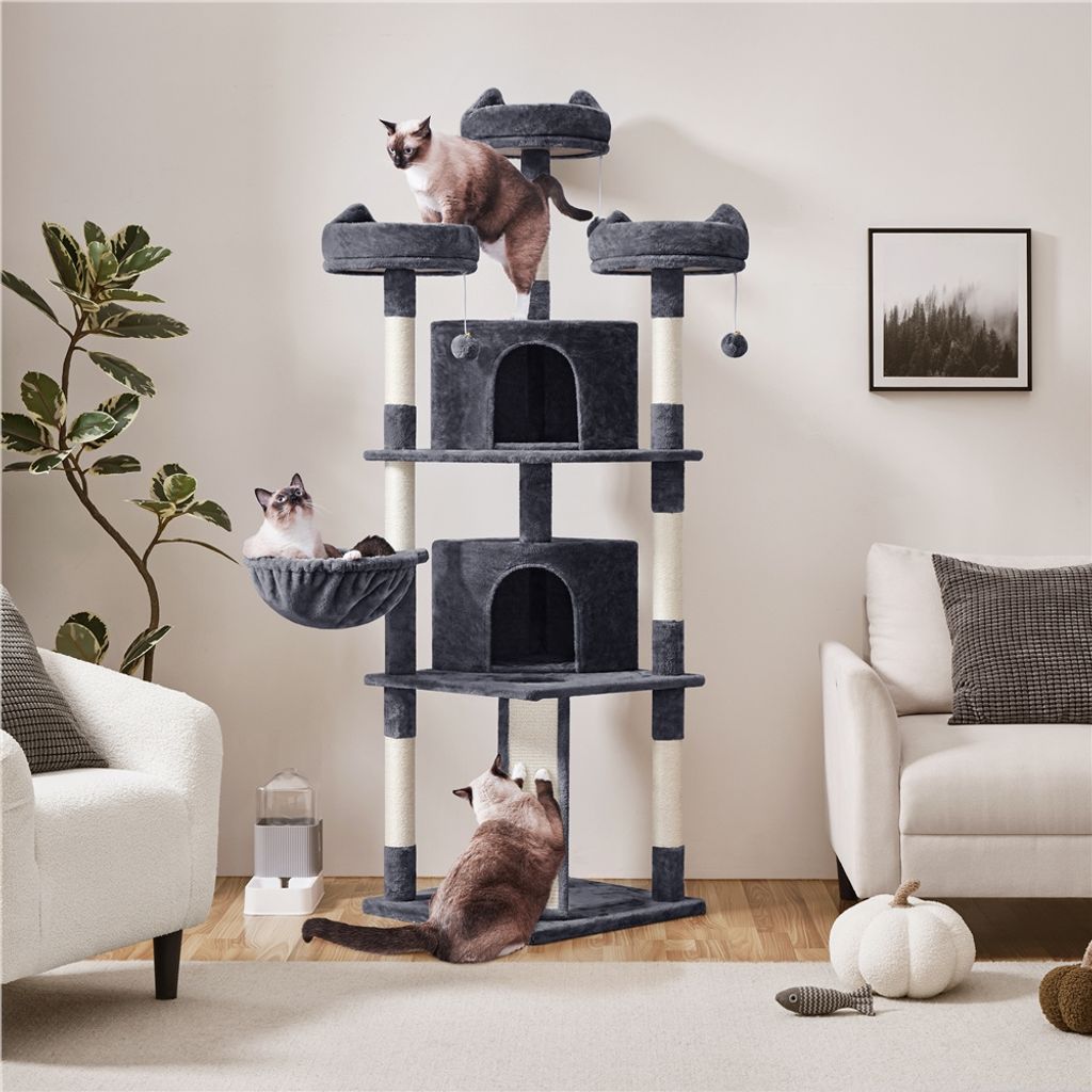 A multi-level cat tree with several cats interacting with it, placed in a living room setting with furniture and decor.