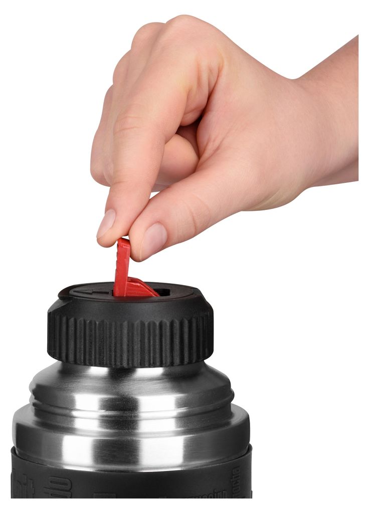 A hand is shown operating a red lever on the lid of a thermos.