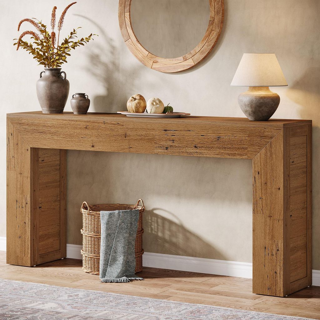 A wooden console table with decorative items and a lamp.