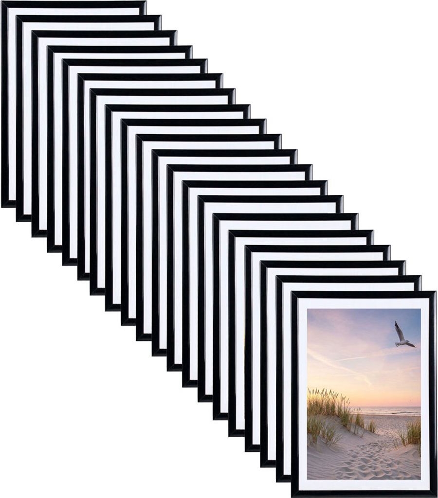 A stack of black picture frames arranged diagonally, with one frame showing a beach scene at sunset.