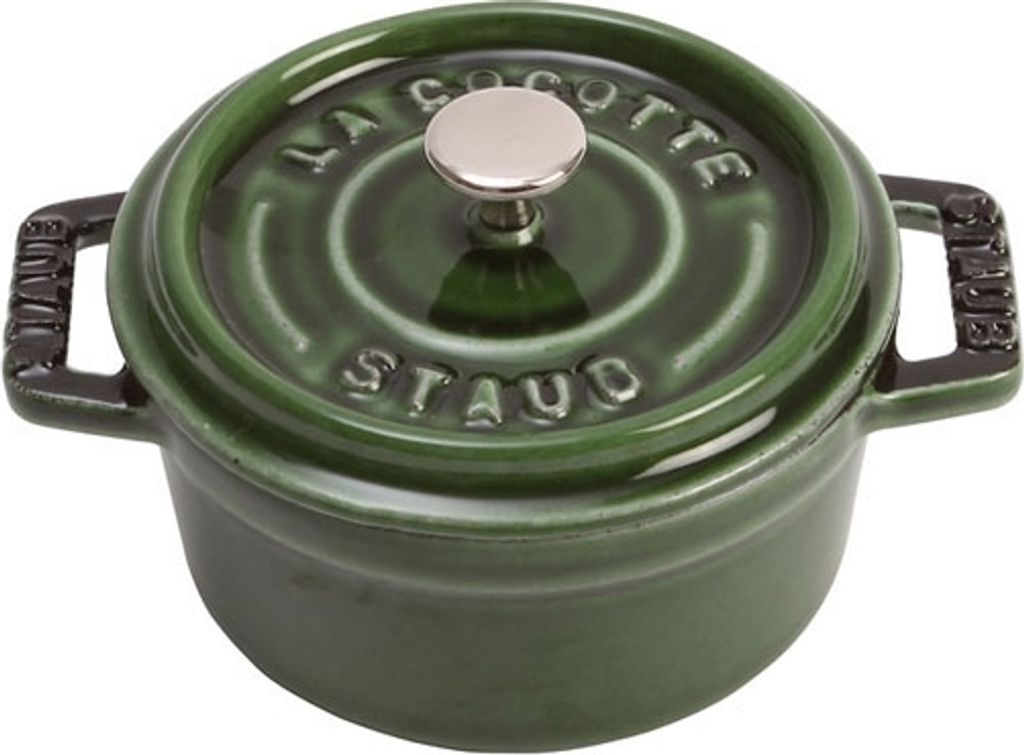 A green Staub cocotte pot with a silver knob on a white background.