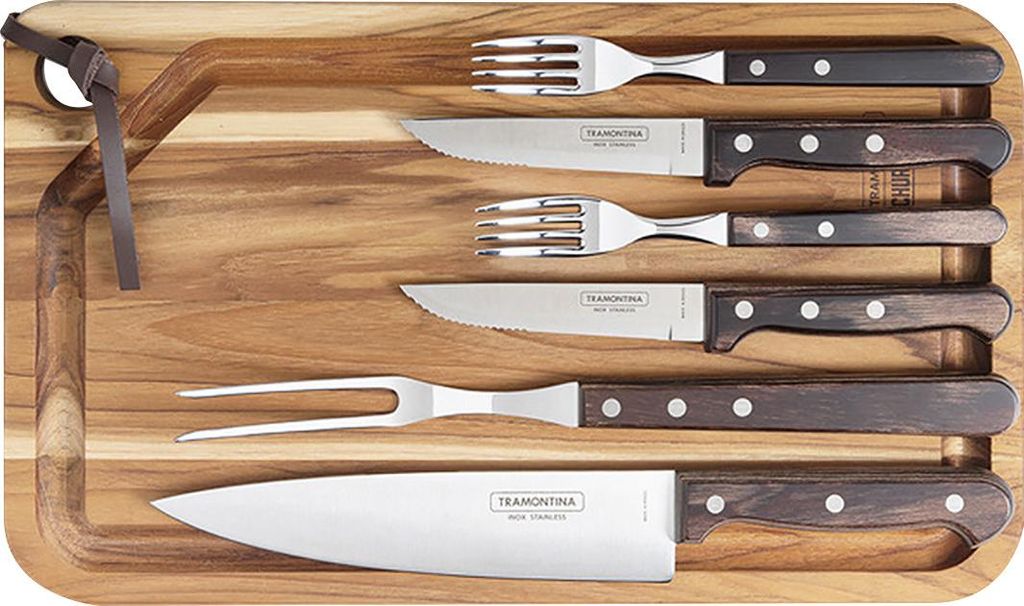 A set of barbecue utensils neatly arranged on a wooden cutting board.