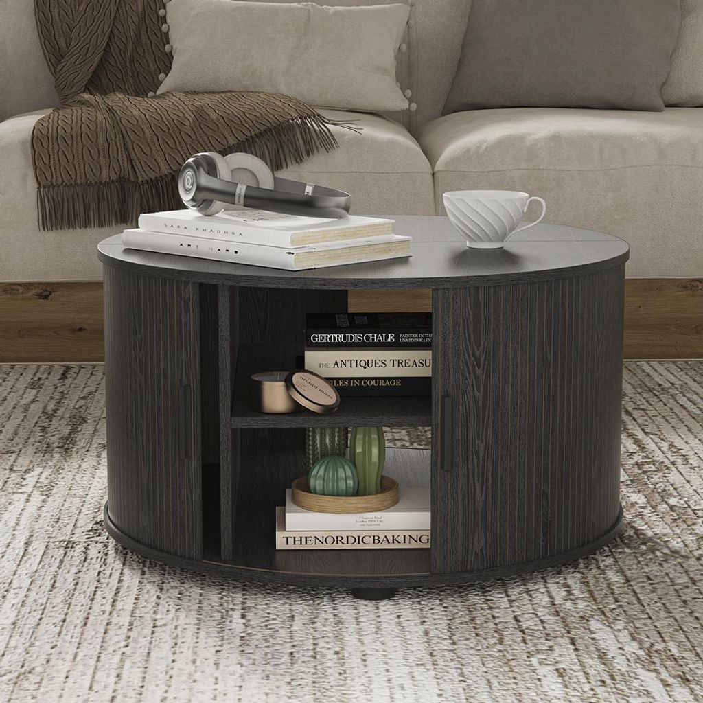 A round coffee table with storage is placed in a living room setting, next to a sofa.