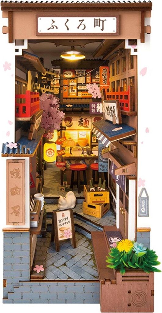 A miniature diorama of a Japanese alleyway with shops and cherry blossoms.